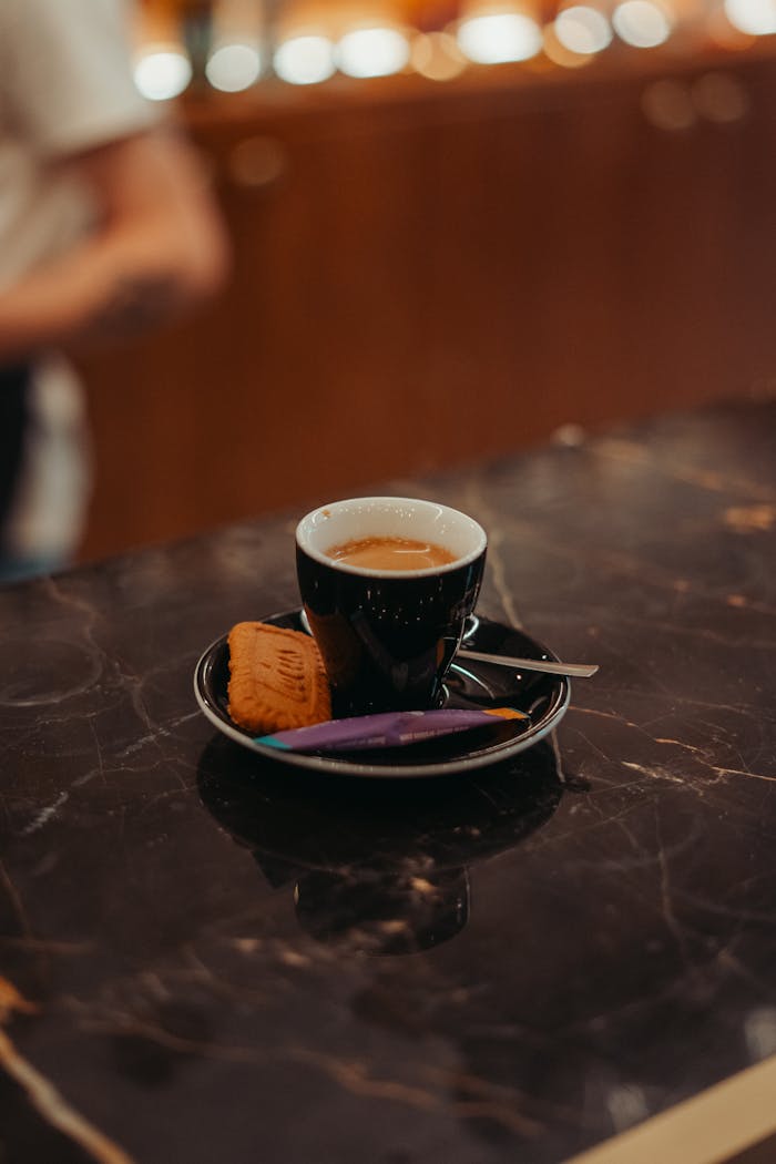 A stylish shot of espresso with snacks on a marble counter in Rennes, France.